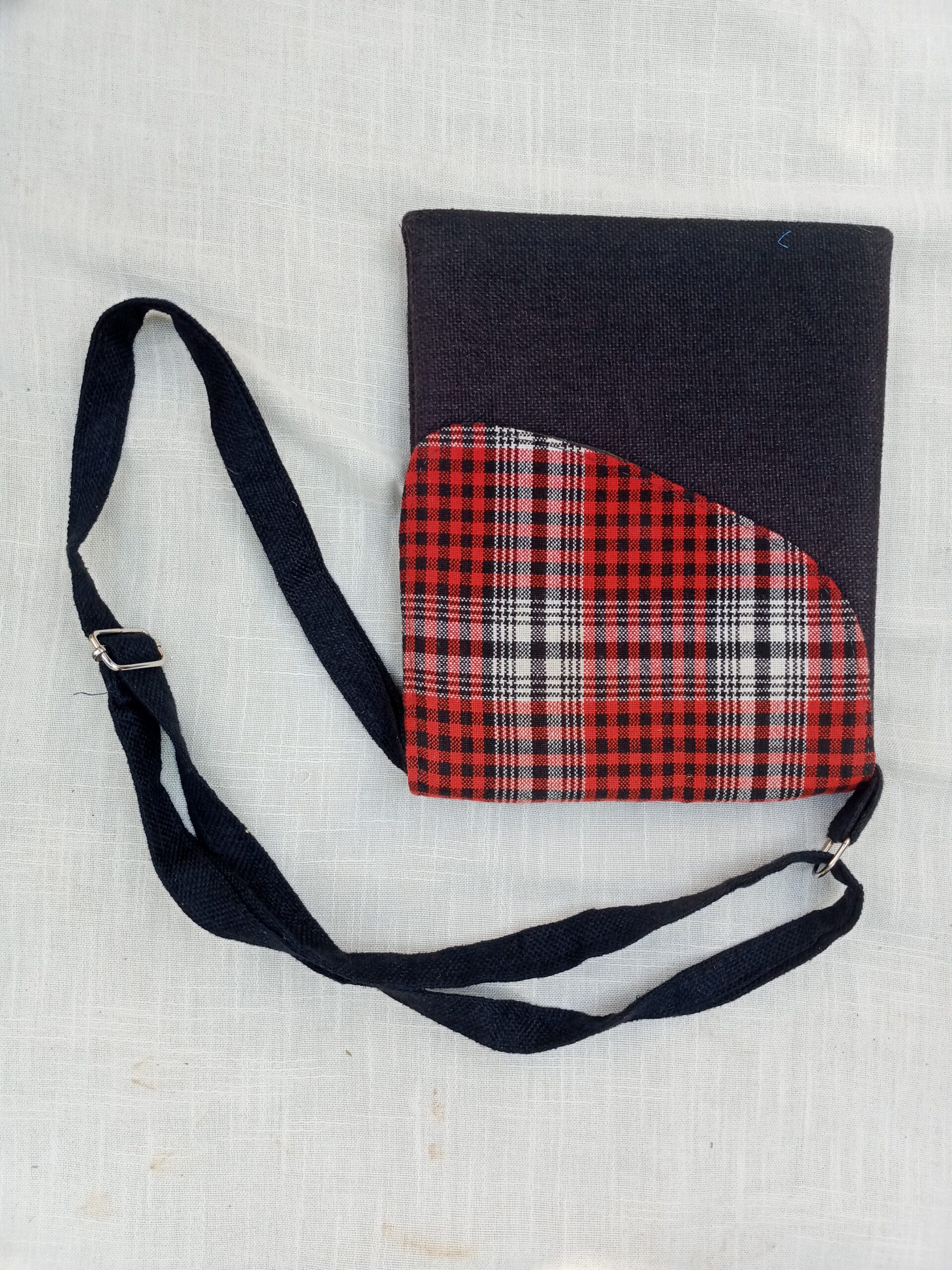 A compact crossbody bag featuring a bold African wax-print (Ankara/Kente-style) flap set against a rich burgundy woven fabric body, finished with a matching adjustable shoulder strap — a vibrant, everyday statement piece.