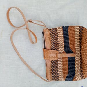 Handwoven sisal crossbody bag with striped tribal detailing and genuine leather strap. A durable, eco-friendly accessory that blends rustic African craftsmanship with everyday functionality.