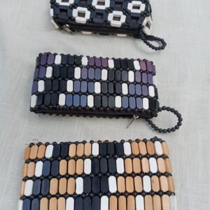 Handmade wooden beaded clutch bag with a chic zip closure and matching beaded wrist strap. A bold, tribal-inspired accessory that adds artisanal flair to any outfit — available in multiple eye-catching color patterns.