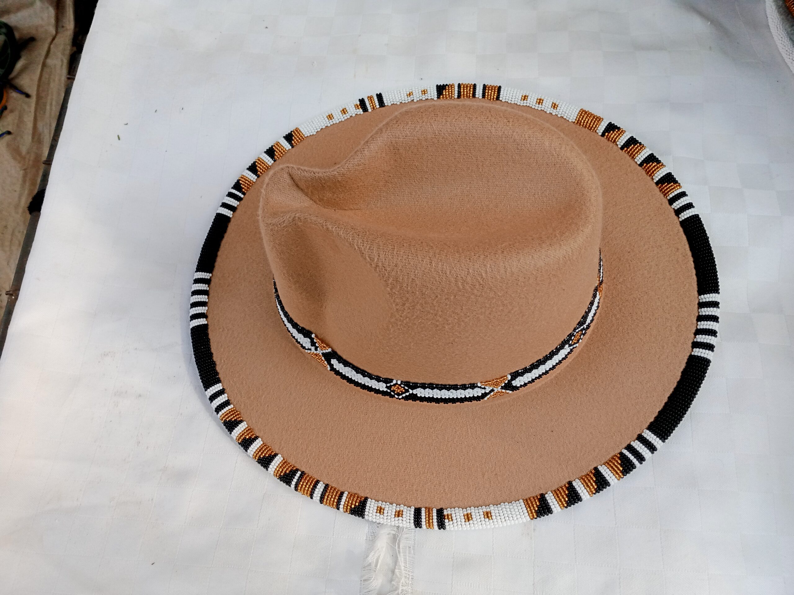 Wide-brim felt fedora with a hand-beaded zigzag trim along the brim and crown — a bold, handmade statement hat available in multiple colors.