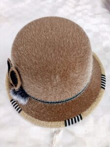 HAT
Faux fur bucket hat with beaded trim, worn for style and warmth
