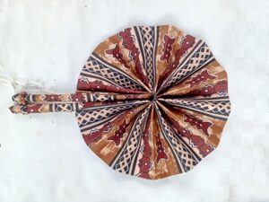 FAN
Handwoven Ankara fabric folding fan, used for cooling and as a decorative accessory