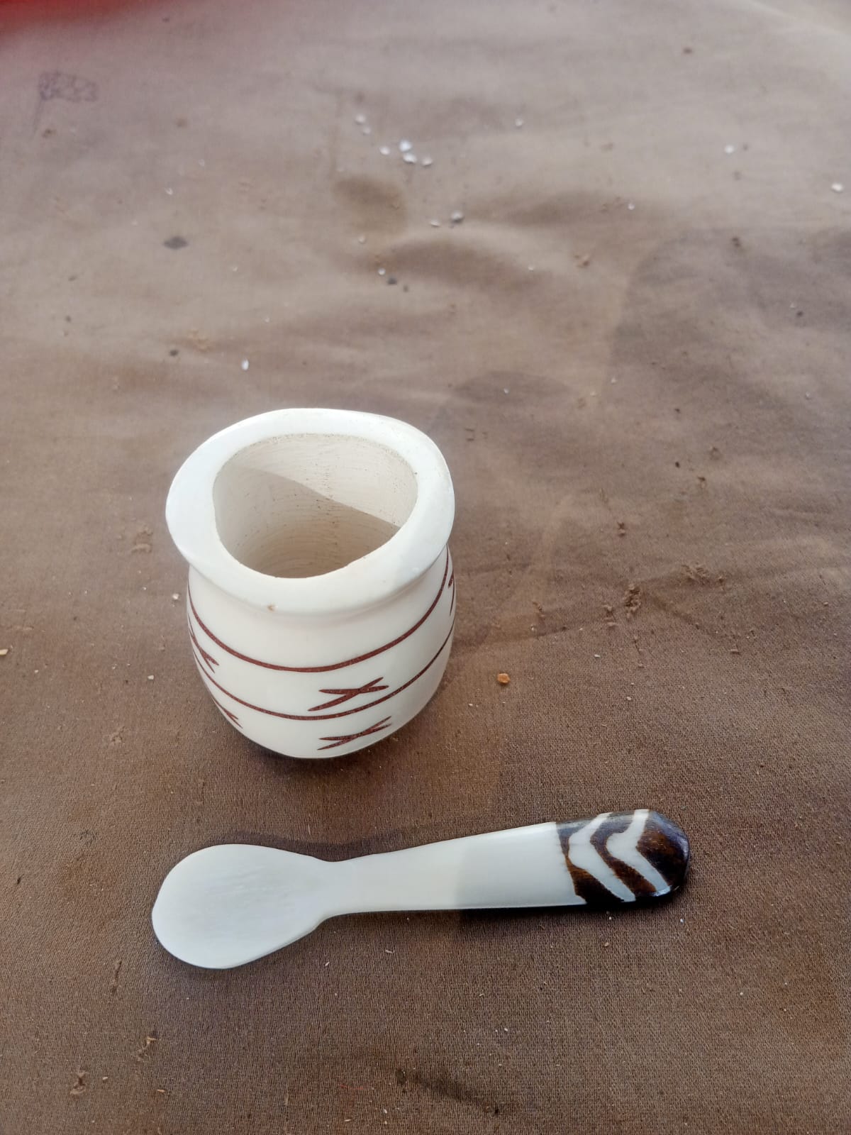 Hand-carved bone spice/salt pot with etched detailing, paired with a matching two-tone spoon featuring horn accents.